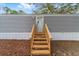Home exterior featuring a wooden staircase leading to the front door, set against a backdrop of neutral siding at 221 Se 167Th Ct, Silver Springs, FL 34488
