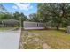 Exterior of home featuring a carport, wood steps, gray siding and green grass at 221 Se 167Th Ct, Silver Springs, FL 34488