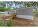 Home exterior with gray siding, landscaping and mature shade trees at 221 Se 167Th Ct, Silver Springs, FL 34488