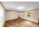 Sunlit living room featuring laminate wood floors, neutral walls, and a smooth transition into the hallway at 221 Se 167Th Ct, Silver Springs, FL 34488
