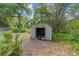 Outdoor shed with green foliage and brown pine straw at 221 Se 167Th Ct, Silver Springs, FL 34488