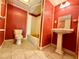 Bathroom with red walls, white fixtures, and a tiled floor at 3682 Jack Pine Ln, Ormond Beach, FL 32174