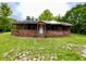 Quaint brick and wood home featuring a cozy front porch and a spacious yard at 3682 Jack Pine Ln, Ormond Beach, FL 32174