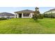 Expansive backyard showcasing a lush lawn, mature tree, and rear home exterior, perfect for outdoor activities at 3940 Se 5Th Ave, Ocala, FL 34480