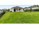 Large, grassy backyard with a covered patio and a black fence, ideal for outdoor entertaining at 3940 Se 5Th Ave, Ocala, FL 34480