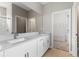 Bathroom featuring a double vanity with white cabinetry, light countertop, and access to the closet at 3940 Se 5Th Ave, Ocala, FL 34480