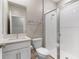 Bathroom featuring tiled glass shower, a toilet and sink with a white cabinet at 3940 Se 5Th Ave, Ocala, FL 34480