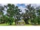 Covered community gazebo with stone pillars and roof nestled amongst large, shady trees at 3940 Se 5Th Ave, Ocala, FL 34480