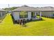 Beautiful backyard view with a covered patio and well-maintained lawn surrounded by lush landscaping at 1192 Via Galuppi St, Kissimmee, FL 34759