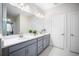 Modern bathroom with double vanity, white countertop, gray cabinets, and ample lighting at 1192 Via Galuppi St, Kissimmee, FL 34759