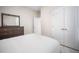 Neat bedroom featuring a bed with white linens, dresser, and white double door closet at 1192 Via Galuppi St, Kissimmee, FL 34759
