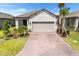 Charming single-story home featuring a two-car garage, well-maintained landscaping, and a brick driveway at 1192 Via Galuppi St, Kissimmee, FL 34759