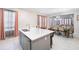 Kitchen island featuring stainless steel sink, bar stool seating, and open floor plan to the dining and living area at 1192 Via Galuppi St, Kissimmee, FL 34759