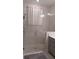 Glass enclosed shower with white tile and gray accents, showcasing modern bathroom design at 1192 Via Galuppi St, Kissimmee, FL 34759