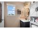 Bright bathroom features a window, sink, large circular mirror, and a cabinet at 24 Sapphire Way, Ocala, FL 34472