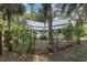 Exterior view of the home's backyard showcasing lush landscaping, a metal roof and mature trees at 5881 Avenue H, Mc Intosh, FL 32664