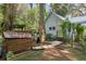 Exterior view of home featuring cottage charm, a walking path, and delightful outdoor structures at 5881 Avenue H, Mc Intosh, FL 32664