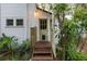 Charming home entrance with a green door, wood steps, and a bright, inviting facade at 5881 Avenue H, Mc Intosh, FL 32664