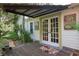 Charming entrance featuring double doors, a covered porch, and lush landscaping at 5881 Avenue H, Mc Intosh, FL 32664