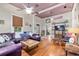 Comfortable living room with wood floors, purple sofa, and plenty of natural light at 5881 Avenue H, Mc Intosh, FL 32664