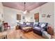 Bright living room features a purple sofa, wood floors, and a ceiling fan at 5881 Avenue H, Mc Intosh, FL 32664