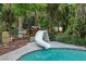 Backyard in-ground pool with a white slide and a flagstone pool deck at 5881 Avenue H, Mc Intosh, FL 32664