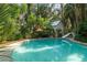 Inviting backyard pool area surrounded by lush, mature landscaping and a charming cottage-style home at 5881 Avenue H, Mc Intosh, FL 32664