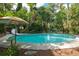 Expansive in-ground pool featuring a slide and surrounded by a stone border and lush greenery at 5881 Avenue H, Mc Intosh, FL 32664