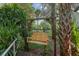 Charming wooden porch swing nestled in a lush, tropical backyard setting at 5881 Avenue H, Mc Intosh, FL 32664