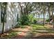 Brick walkway leads to the backyard with a manicured lawn and lush greenery, adding charm to the property at 5881 Avenue H, Mc Intosh, FL 32664