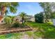 Lush backyard featuring a patio area, well-maintained lawn, palm trees, and privacy hedging at 916 Ashmeade Ct, Port Orange, FL 32127