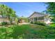 Lush backyard featuring a patio, palm trees, and a sunroom with ample natural light at 916 Ashmeade Ct, Port Orange, FL 32127