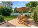 Outdoor patio featuring an umbrella-covered table and chairs surrounded by lush landscaping and a white fence at 916 Ashmeade Ct, Port Orange, FL 32127