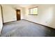 Bedroom with gray carpet, dark trim, closet and simple lamp at 11027 Sw 75Th Ave, Ocala, FL 34476