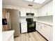 Kitchen with stainless steel refrigerator, black stove, and white cabinets at 11027 Sw 75Th Ave, Ocala, FL 34476
