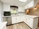 Corner kitchen with stainless steel dishwasher, white cabinets and marble countertops at 11027 Sw 75Th Ave, Ocala, FL 34476