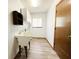 Laundry room with wooden floors, a utility sink, and storage cabinets at 11027 Sw 75Th Ave, Ocala, FL 34476