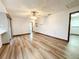 Spacious living room with wood flooring, a ceiling fan, and a view of the kitchen at 11027 Sw 75Th Ave, Ocala, FL 34476