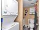 Efficient bathroom area with stacked washer and dryer, toilet, vanity, and wall-mounted cabinet for compact living at 487 Midway Dr # B, Ocala, FL 34472