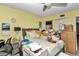 Bedroom with yellow walls, large bed, sunflowers and small workspace at 487 Midway Dr # B, Ocala, FL 34472
