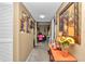 Inviting hallway with beige walls and carpet leading to a dining area, adorned with framed photos and a decorative console table at 487 Midway Dr # B, Ocala, FL 34472