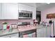 Charming kitchen design with updated cabinets, stainless steel microwave, and pink accents creating a cheerful atmosphere at 487 Midway Dr # B, Ocala, FL 34472