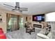 Cozy living room with a ceiling fan, fireplace, large TV, and comfortable seating for relaxing and entertaining at 487 Midway Dr # B, Ocala, FL 34472