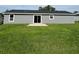 A large backyard features a gray home with windows and sliding glass doors at 15433 Sw 47Th Avenue Rd, Ocala, FL 34473
