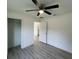 Bedroom features ceiling fan, gray wood flooring, and white door at 15433 Sw 47Th Avenue Rd, Ocala, FL 34473