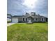 Charming single-story home featuring a manicured lawn, attached garage, and gray exterior at 15433 Sw 47Th Avenue Rd, Ocala, FL 34473