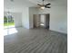 Open-concept living area with wood-look floors, neutral walls, ceiling fan, and sliding glass doors at 15433 Sw 47Th Avenue Rd, Ocala, FL 34473
