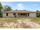 Expansive backyard view showcases a spacious lawn with home featuring a covered patio and multiple windows at 9879 Sw 38Th Ave, Ocala, FL 34476