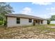 Backyard featuring a well-maintained lawn with rear view of home boasting ample natural light and stucco finish at 9879 Sw 38Th Ave, Ocala, FL 34476