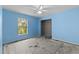 A bright blue bedroom with a ceiling fan and a window offers natural lighting at 9879 Sw 38Th Ave, Ocala, FL 34476